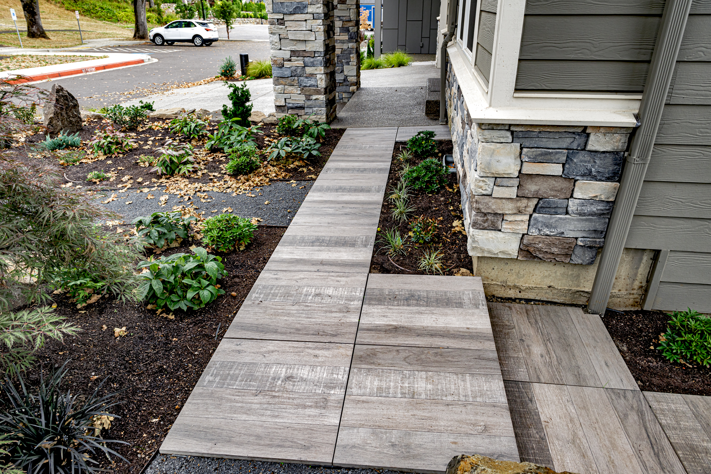 porcelain paver walkway wraps around a house