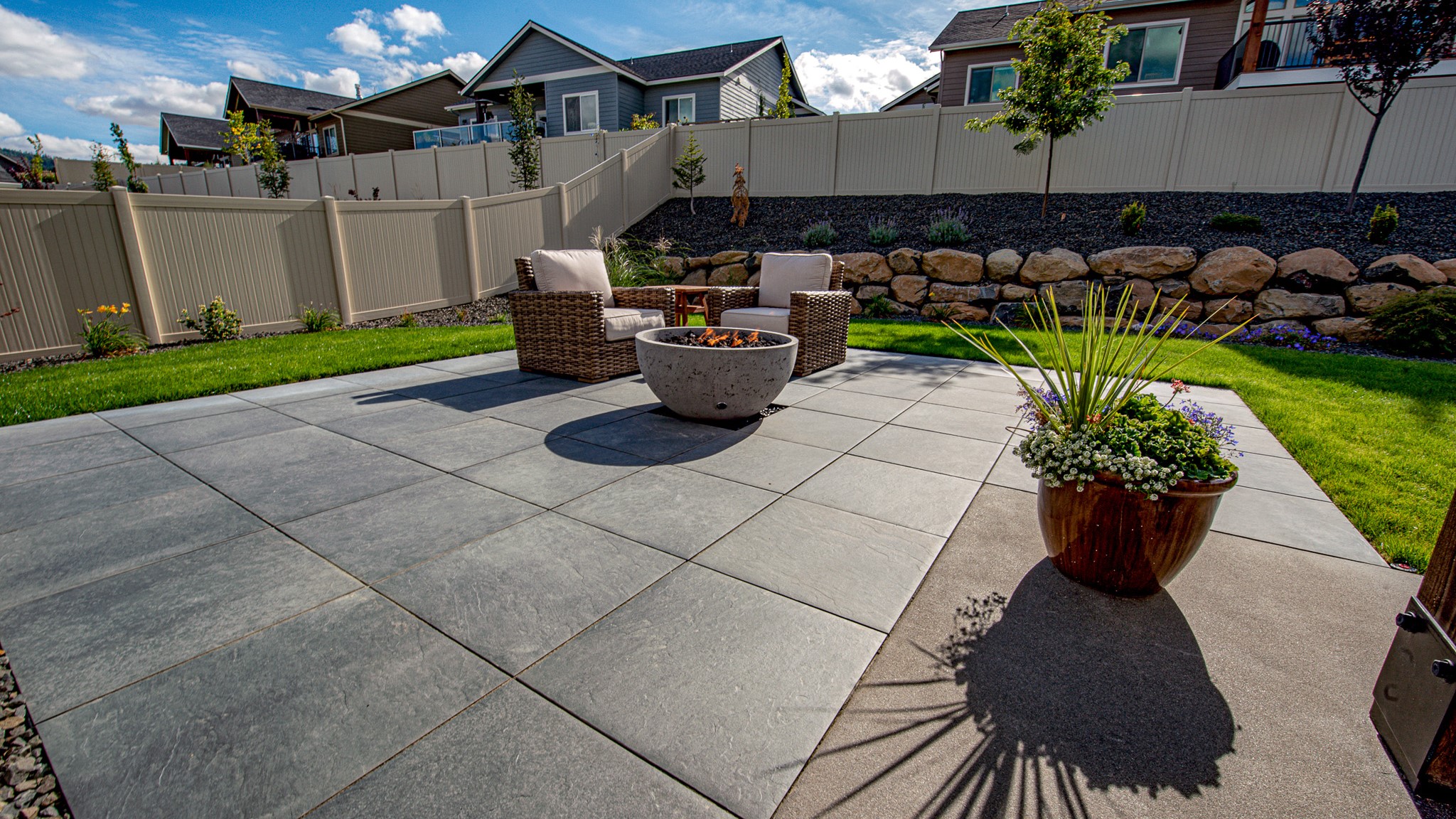 Porcelain pavers provide a canvas for a fire bowl and patio furniture